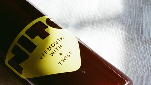 Bottle of vermouth with a yellow label on a white background